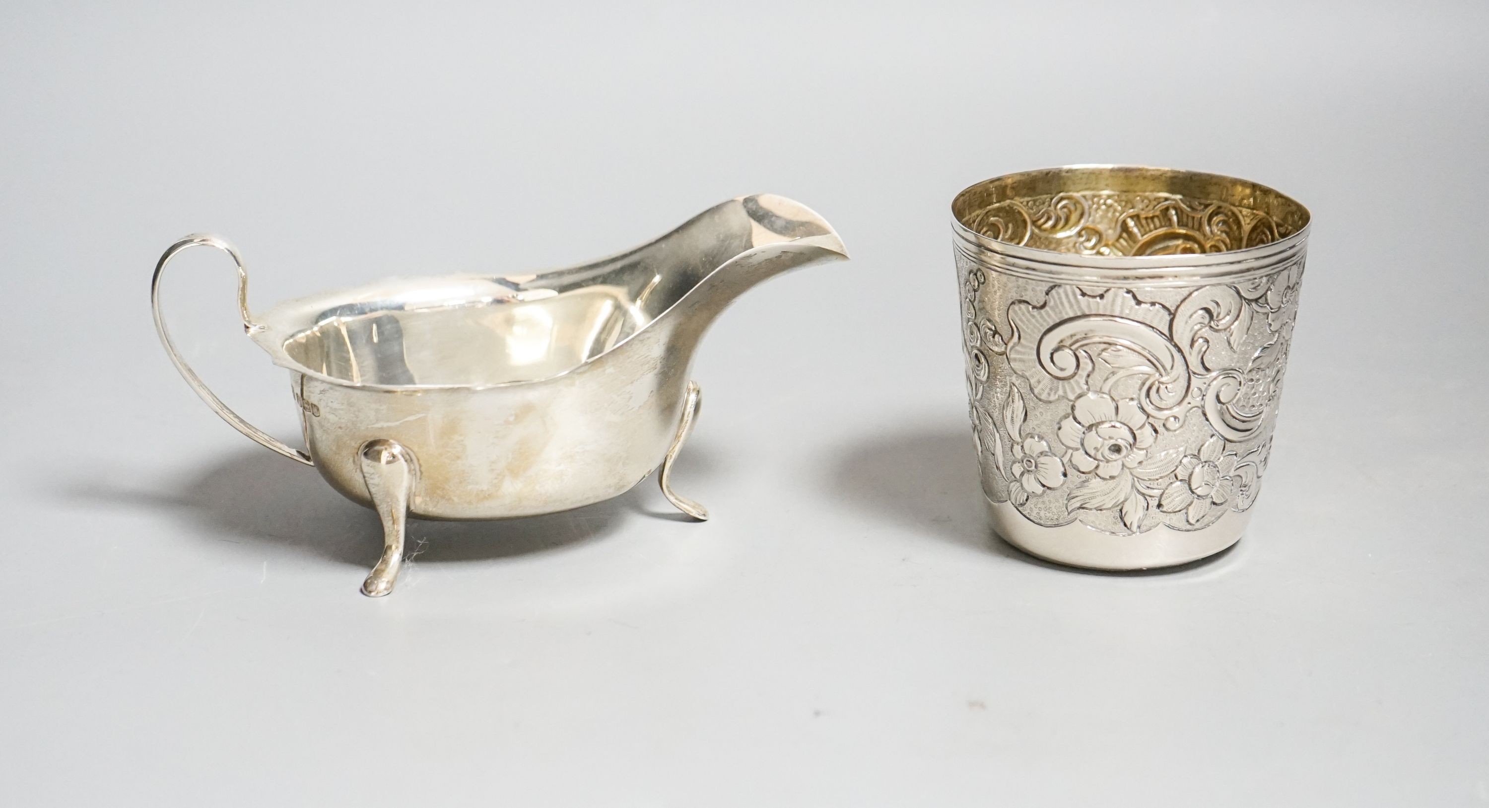 A 19th century Portuguese white metal tumbler, 7cm and a later silver sauceboat, 6.5oz.